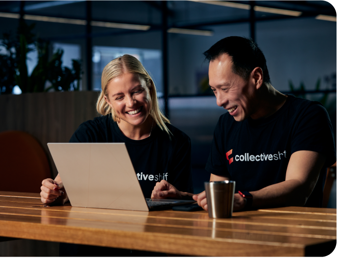 Two Collective Shift team members working at a laptop
